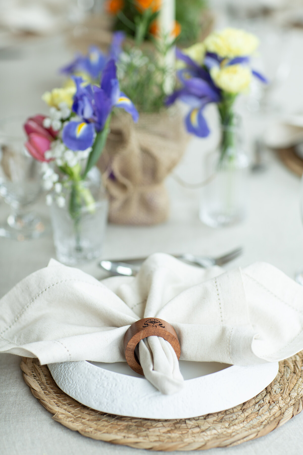 A Marrigold Wellness place setting with linen, flowers, and a signature napkin ring
